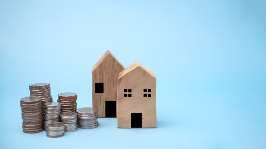 Stack coins with house model background. business finance investment and savings insurance home loan development concept.