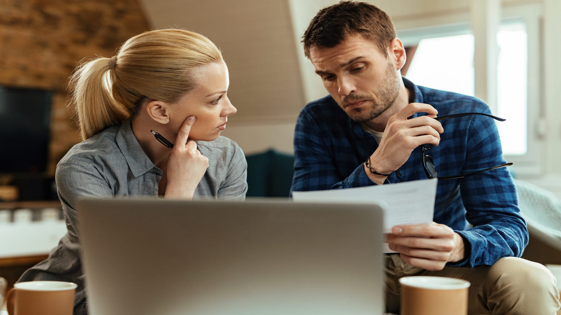 Adelaide couple reviewing property documents and laptop while planning bridging finance before selling